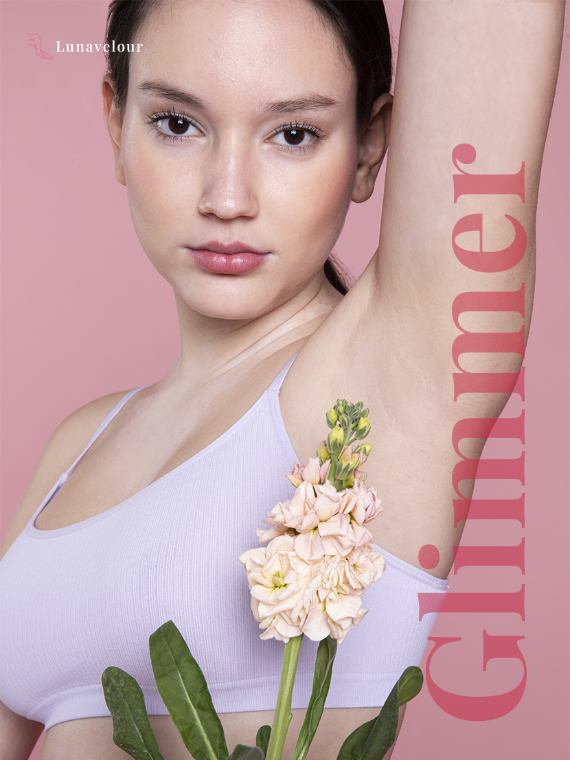 Woman with floral design on arm against pink background, featuring the brand 'Lunavelour'.